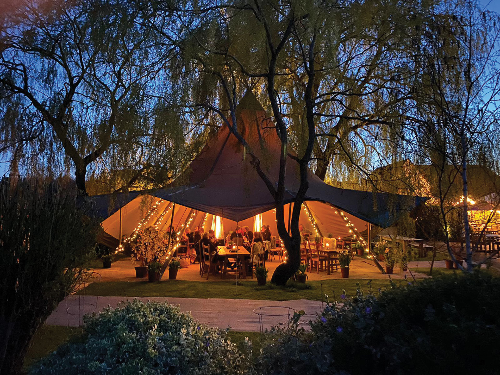 Trees tent/tipi with seating lights and people