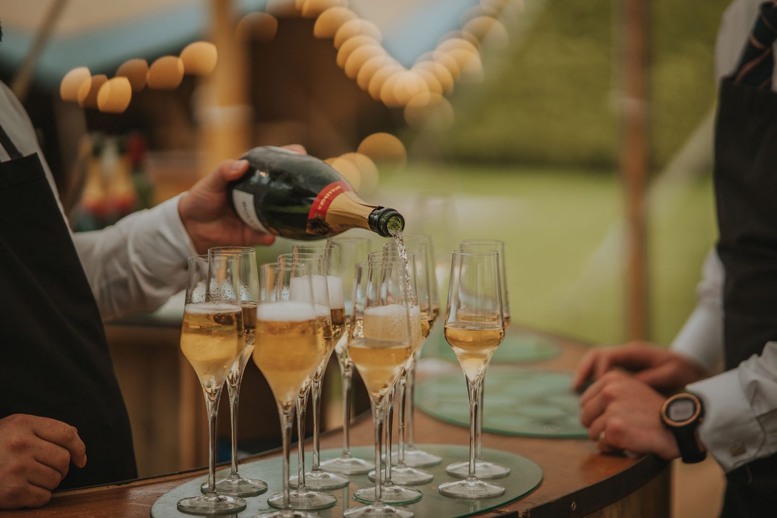 Champagne bottle pouring into glasses