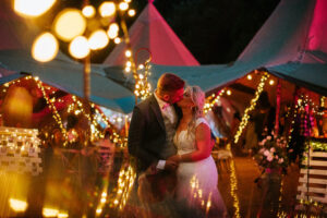 Bride and Groom kiss outside a tipi wedding at night with beautiful lighting