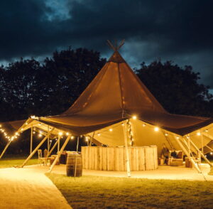Single tipi glowing at a winter party